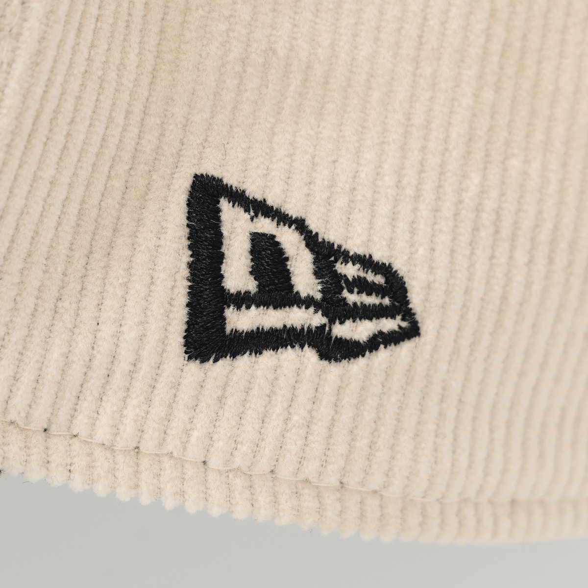 Cappellino BVB New Era 9Forty Cord Lifestyle color beige con logo ricamato, primo piano della trama del tessuto.