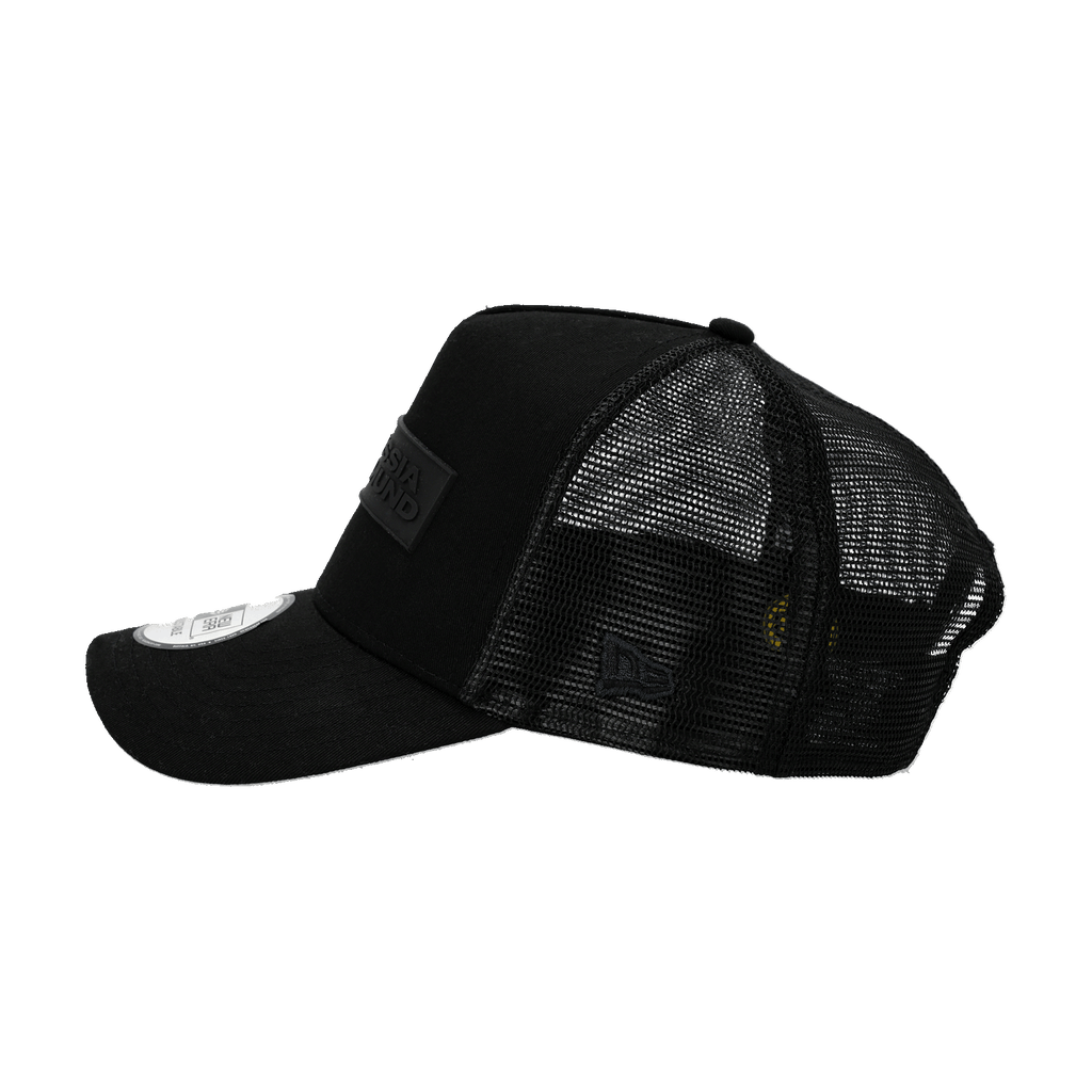 Schwarze BVB New Era Trucker Cap mit Mesh-Einsatz und aufgesticktem Borussia Dortmund Logo, seitliche Ansicht.