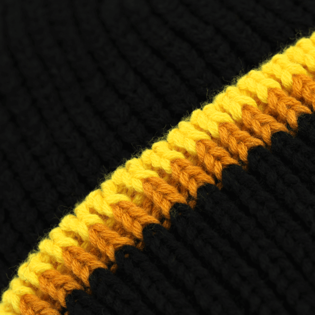 Vue détaillée d'un bonnet tricoté du BVB aux couleurs noir et jaune, inspiré du style rétro des années 70.