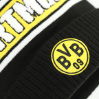 Vista dettagliata del berretto con pompon nero e giallo del BVB di New Era, con logo BVB ricamato e scritta “DORTMUND”.