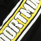 Immagine del berretto con pompon del BVB di New Era con la scritta “DORTMUND” in bianco su sfondo giallo-nero, perfetto per i tifosi in inverno.