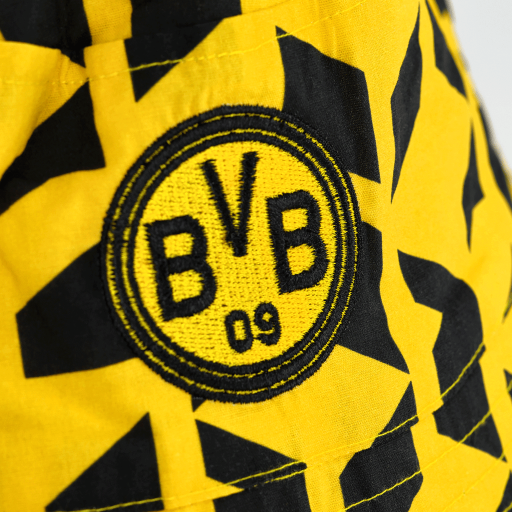 Chapeau de pêcheur noir et jaune du BVB, orné du logo BVB 09 brodé et d'un motif géométrique. Idéal pour les supporters du Borussia Dortmund.