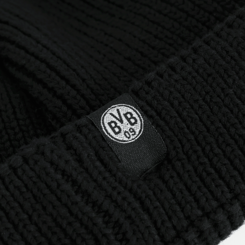 Schwarze BVB Fischerbeanie mit auffälligem BVB-Logo auf einem gewebten Etikett; ein stilvolles Fan-Accessoire für Borussia Dortmund Fans.