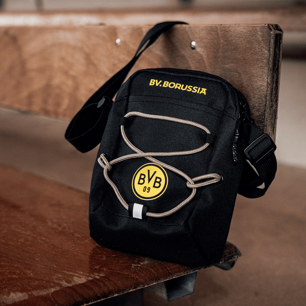 Schwarze BVB-Schultertasche mit gelbem BVB-Logo, gelber Aufschrift 'BVB Borussia' und grauen Kordeldetails, ideal für Fans von Borussia Dortmund.