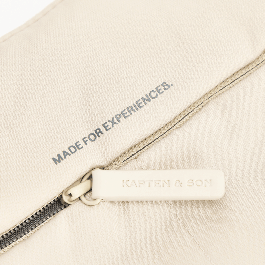 Bolso Skara Cloud de BVB x Kapten & Son, de color beige, con cremallera y la inscripción «Made for Experiences», así como el logotipo de Kapten & Son.
