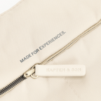 Bolso Skara Cloud de BVB x Kapten & Son, de color beige, con cremallera y la inscripción «Made for Experiences», así como el logotipo de Kapten & Son.