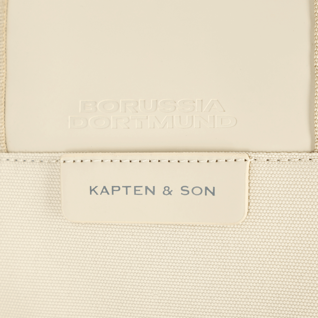 Vista dettagliata dello zaino Bergen Pro color crema della linea BVB X Kapten & Son, con la scritta “Borussia Dortmund” e “Kapten & Son”.