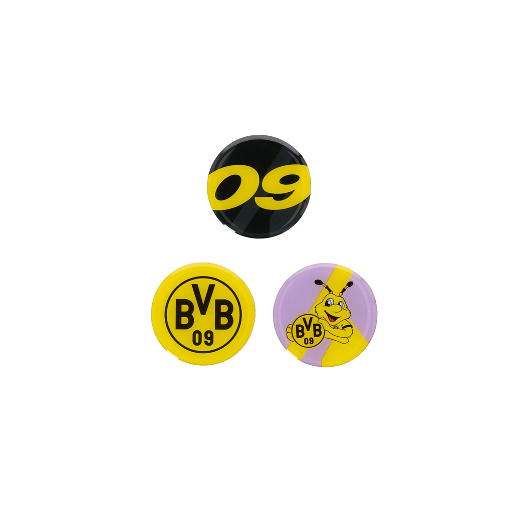 Lot de trois aimants du BVB avec le logo du club, le chiffre 09 en noir et jaune et le motif EMMA en violet et jaune, comme articles de supporters.