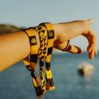 Lot de 3 bracelets « BVB Festival » aux couleurs noir et jaune, ornés de l'emblème du BVB, présentés au poignet dans un cadre naturel.