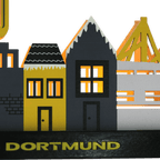A BVB Christmas village featuring illuminated houses in black-and-yellow colors and "Dortmund" lettering as decorative fan merchandise.