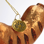Golden glitzernder BVB-Wurst-Dekoelement-Anhänger mit BVB 09-Emblem, Detailaufnahme.