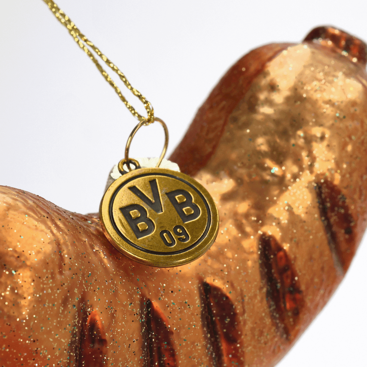 Golden glitzernder BVB-Wurst-Dekoelement-Anhänger mit BVB 09-Emblem, Detailaufnahme.