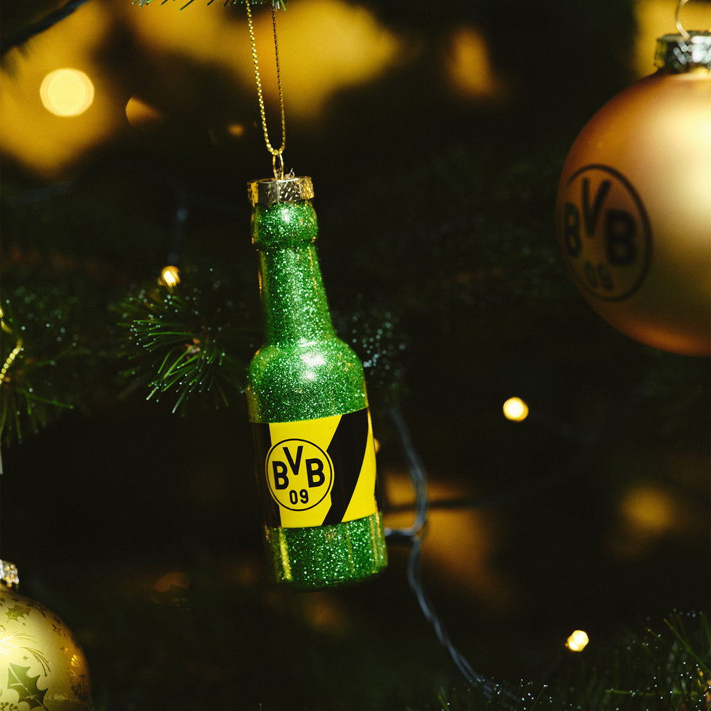 Glitzernde grüne BVB-Bierflaschen-Weihnachtskugel mit schwarzgelbem Design und BVB-Logo, hängend an einem Weihnachtsbaum.