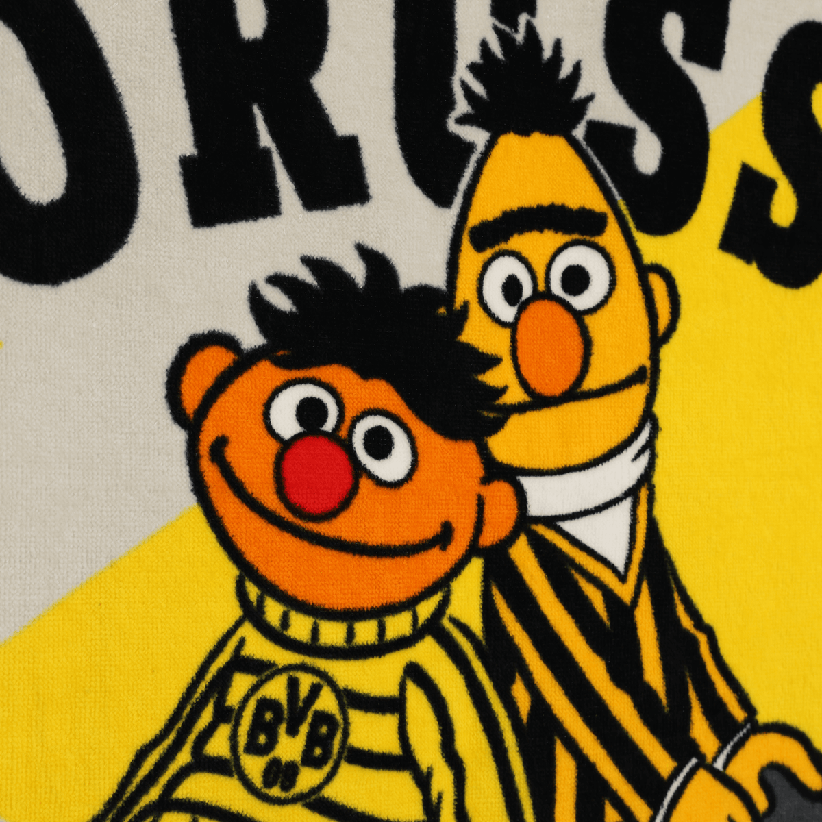 BVB『セサミストリート』バスタオル 70×140 cm。アーニーとバートが描かれた黒と黄色のデザインにBVBのロゴが入っており、子供向けのファンアイテムとして最適です。
