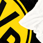 Detailansicht einer schwarzgelben BVB-Decke mit großem Vereinslogo und weicher Sherpa-Innenseite.