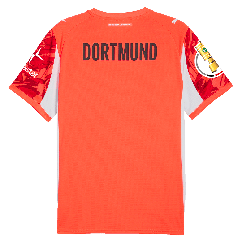 Maglia da calcio rossa con la scritta DORTMUND, dettagli bianchi sui lati e maniche a fantasia rossa e bianca. Design di PUMA.