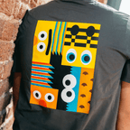 Camiseta gris de hombre de la colección «BVB-Barrio Sésamo», con un diseño abstracto y colorido en la espalda.