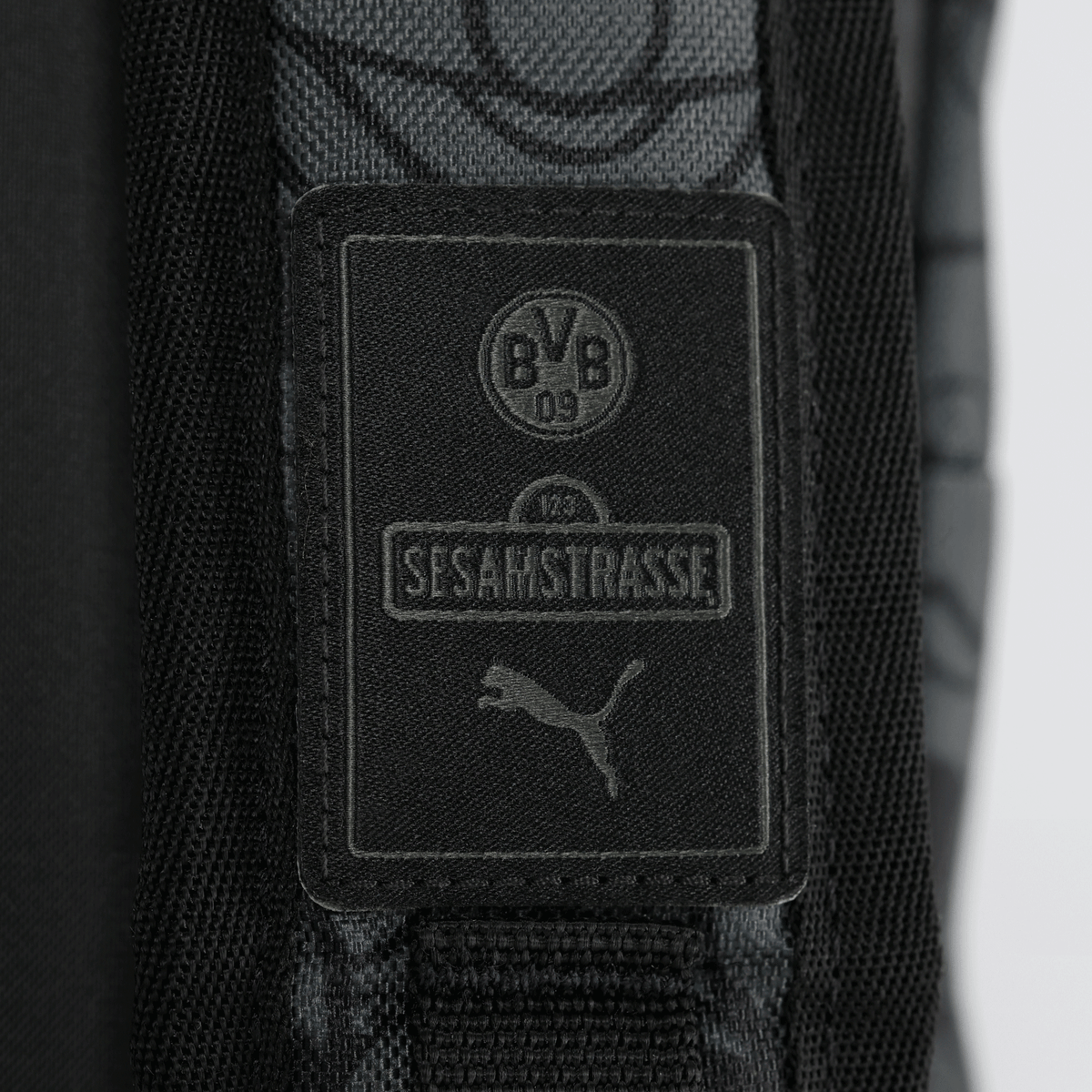 Black-and-yellow BVB Sesame Street backpack with the PUMA logo and BVB emblem, perfect for kids and Borussia Dortmund fans.