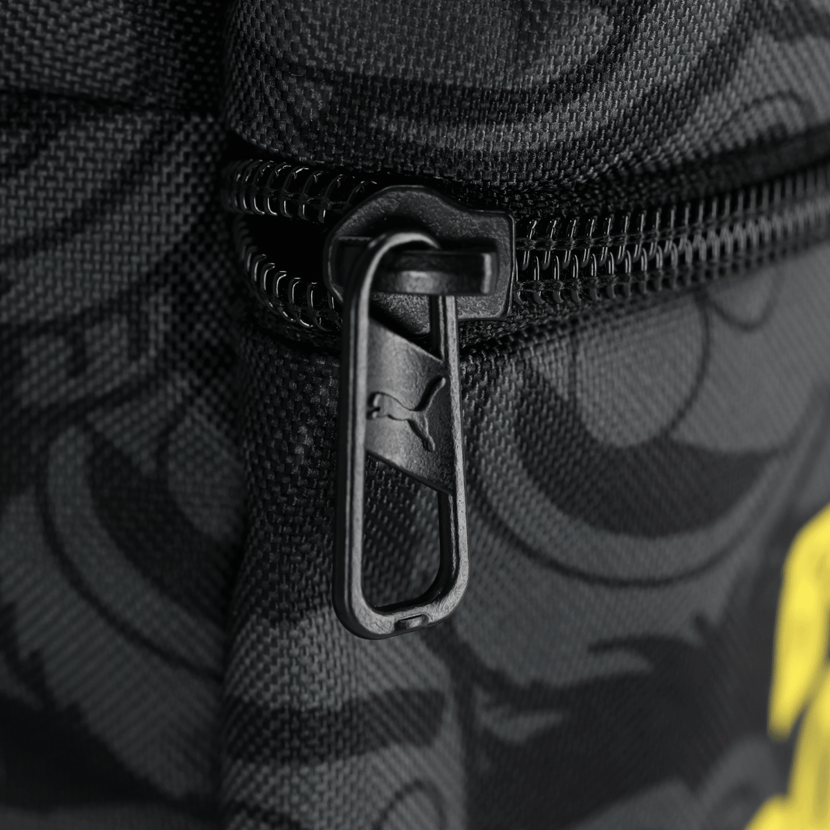 Le sac à dos noir et jaune du BVB, au motif « Sesame Street » et doté d'une fermeture éclair PUMA, est un accessoire pratique pour les supporters de Dortmund.