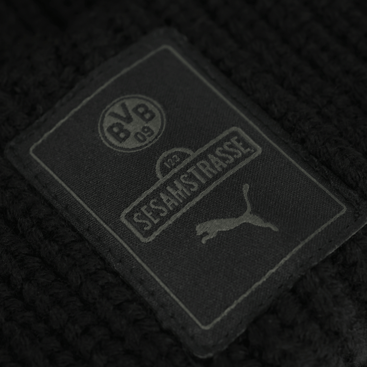 Schwarze BVB-Sesamstraße Beanie mit BVB-Logo, Sesamstraße-Text und PUMA-Logo, idealer Fanartikel für Borussia Dortmund Fans.