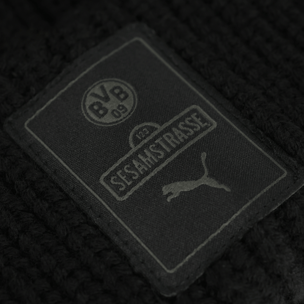 Black BVB Sesame Street beanie featuring the BVB logo, Sesame Street text, and the PUMA logo—the perfect fan item for Borussia Dortmund fans.