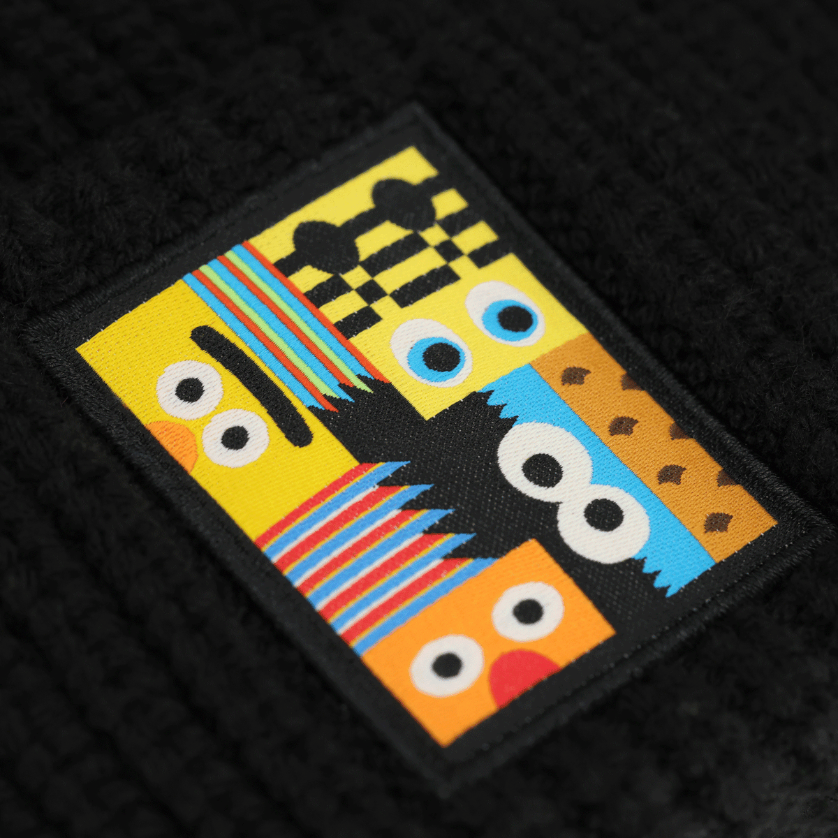 Schwarze BVB-Beanie mit aufgesticktem farbenfrohem Sesamstraße-Motiv, ideal für Fans von Borussia Dortmund und Sesamstraße.