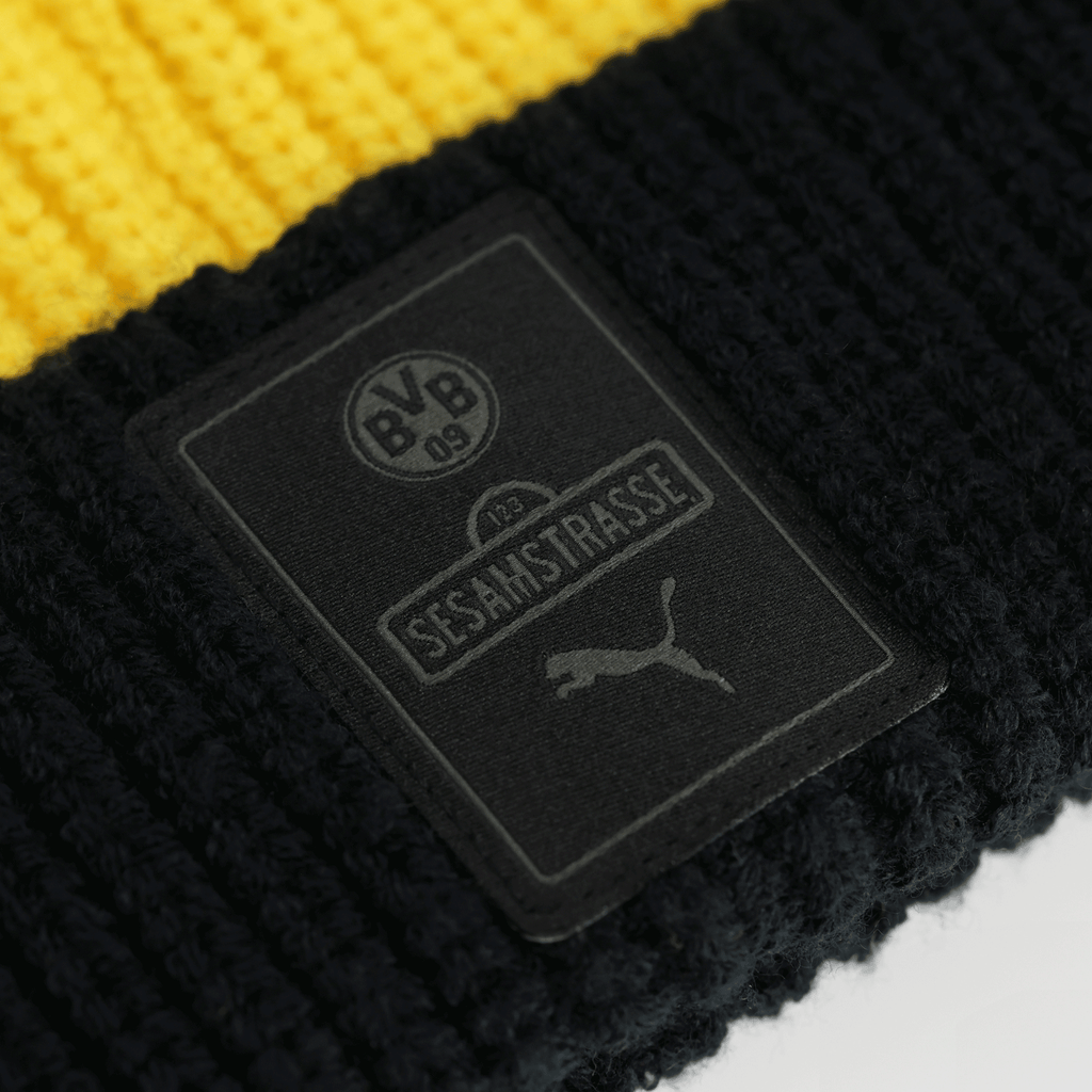 Close-up of the black-and-yellow BVB Sesame Street beanie for kids, featuring the BVB emblem, Sesame Street lettering, and the PUMA logo on the label.