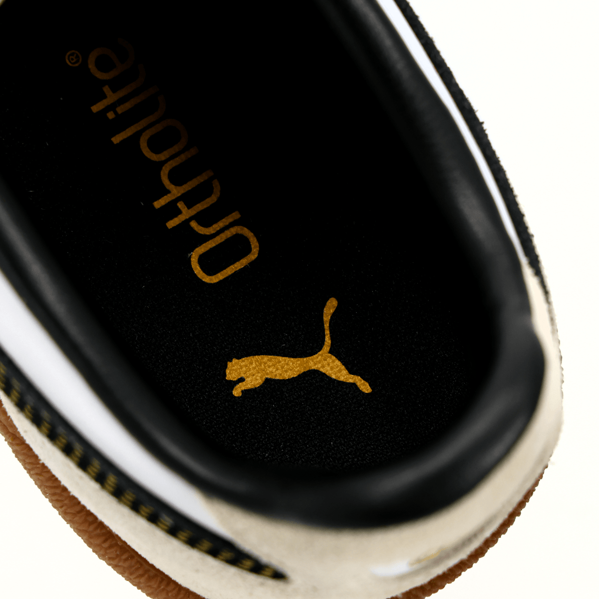 Close-up of the BVB Puma Palermo sneakers in black and white, featuring an Ortholite sole and a gold PUMA logo on the inside of the shoe.