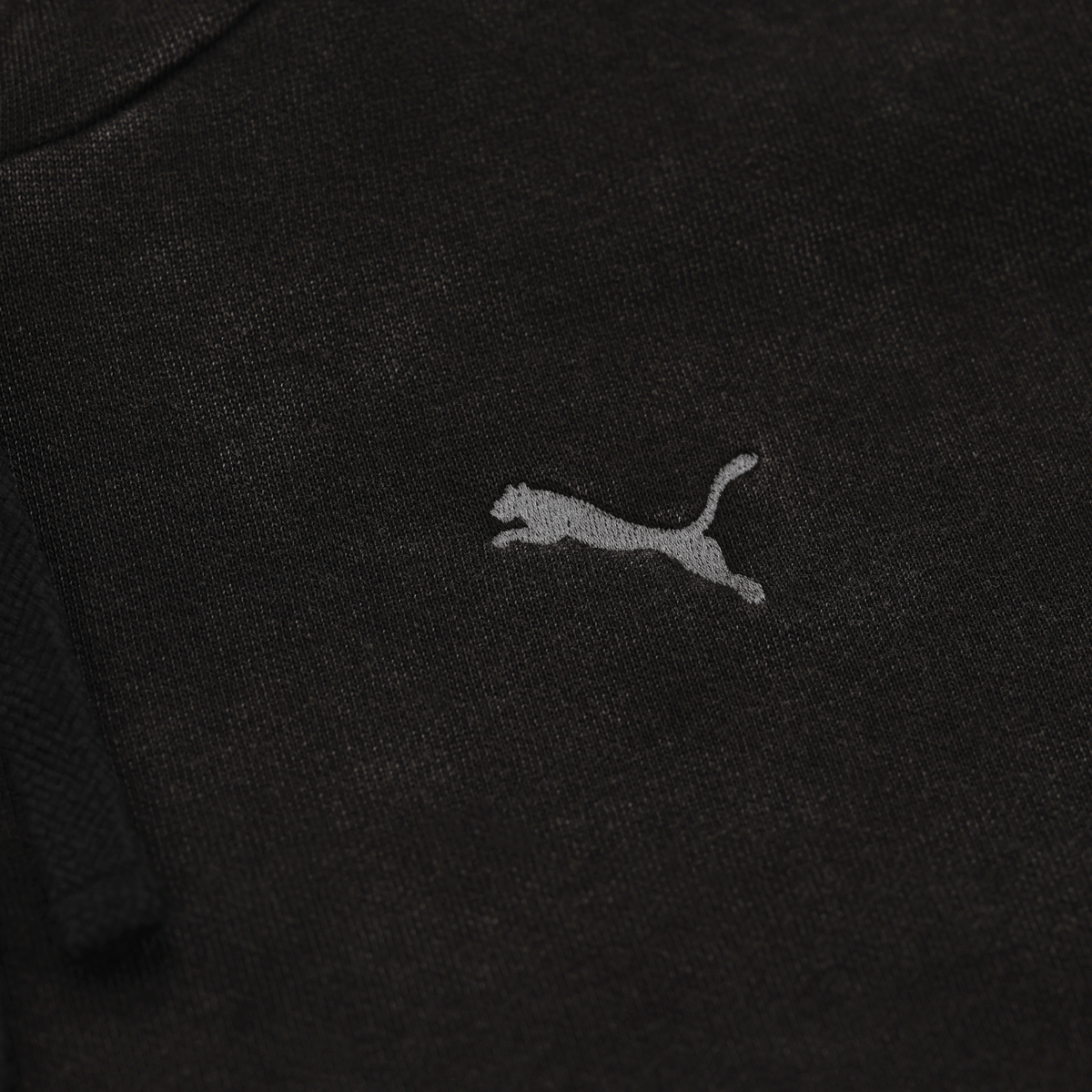 Detailaufnahme eines schwarzen BVB PUMA Ess Elevated Hoodies für Frauen mit sichtbarem PUMA-Logo.