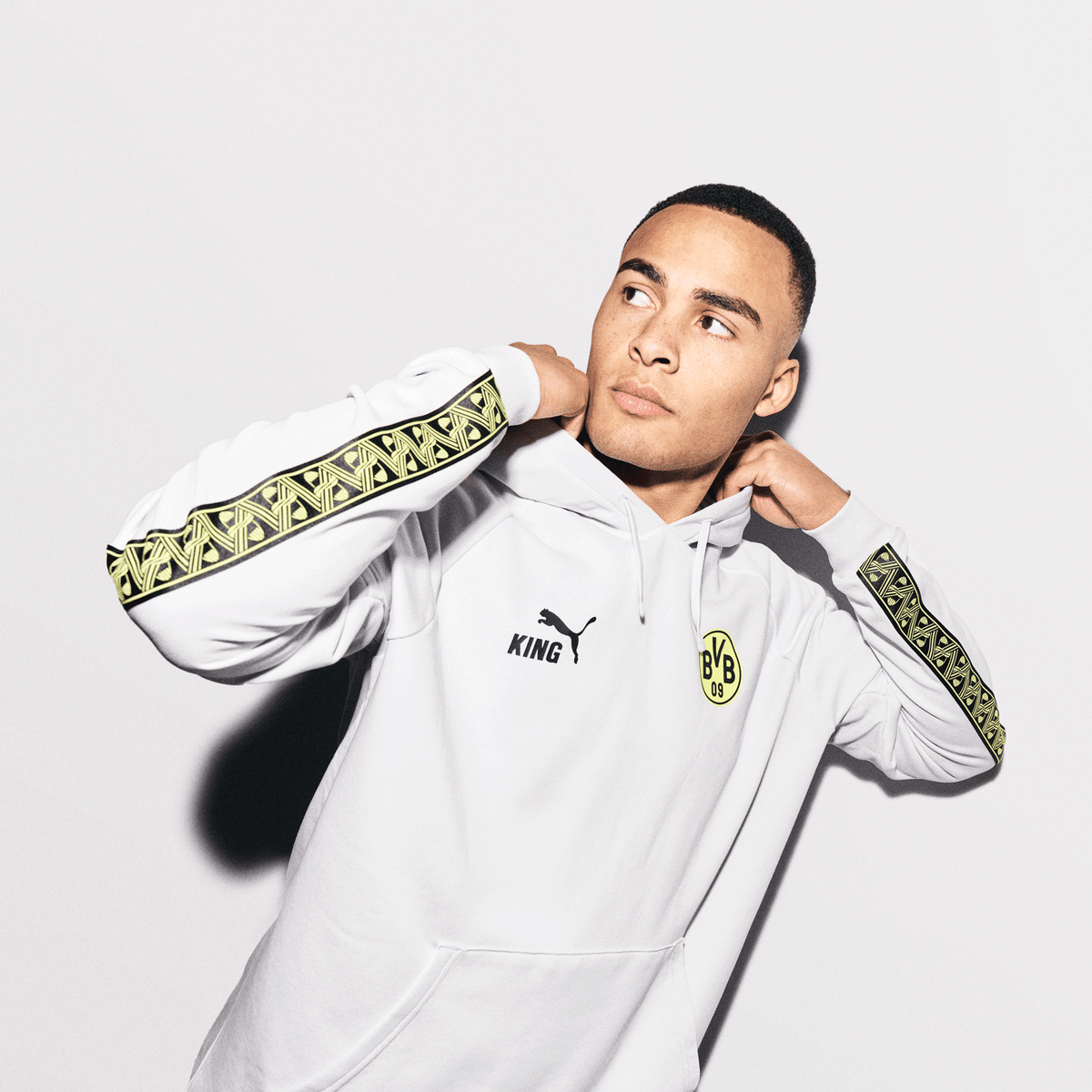 White BVB hoodie from the Silver Mist collection featuring the KING and PUMA logos as well as the BVB 09 emblem. Black-and-yellow accents on the sleeves.