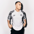 Maglia del BVB "King" bianca e nera con il logo della squadra sul petto, il logo PUMA e un design sportivo, indossata da un uomo in una foto frontale.