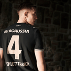 Schwarzes BVB-Trikot der 100 Jahre Rote Erde Special Edition mit goldener Schrift, Nummer 4 und B.V. Borussia Schriftzug, Rückansicht.