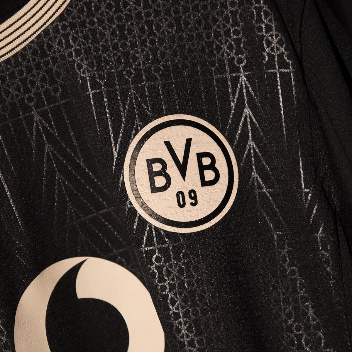 Vue détaillée du maillot spécial noir du BVB « 100 ans de Rote Erde », orné d'un motif abstrait et du logo du BVB.