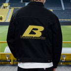 Schwarze BVB x Guess Jeansjacke mit gelbem Dortmund-Schriftzug und auffälligem B-Logo, aufgenommen im SIGNAL IDUNA PARK in Rückenansicht.