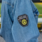 Denim shirt from the BVB x Guess collection, made of blue denim with the BVB logo and a Guess Jeans patch on the sleeve—perfect for Borussia Dortmund fans.