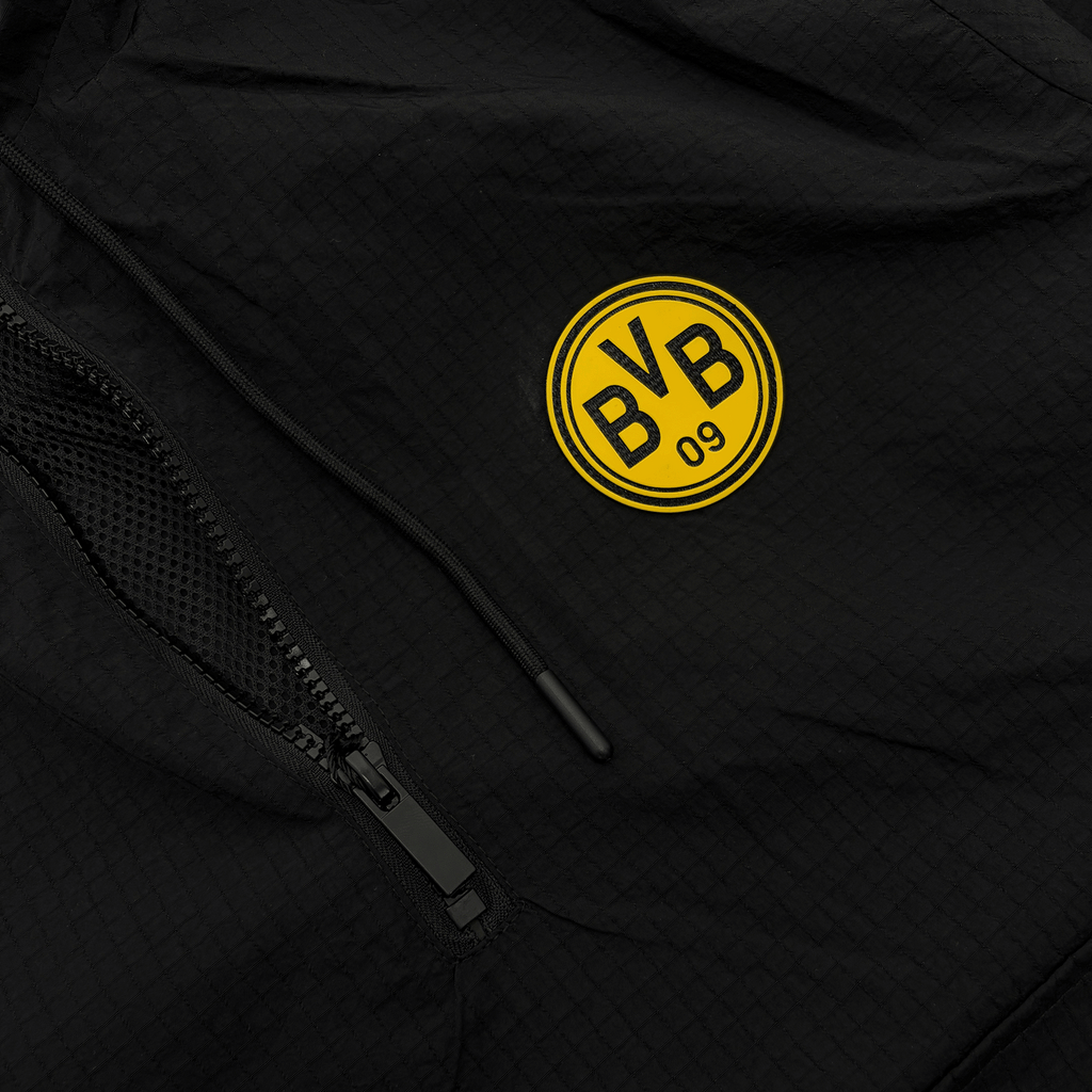 黒を基調としたデザインに黄色のBVBロゴをあしらった、BVBのレトロ風ウィンドブレーカー。ジッパーや素材の質感がはっきりと見えるクローズアップ写真。