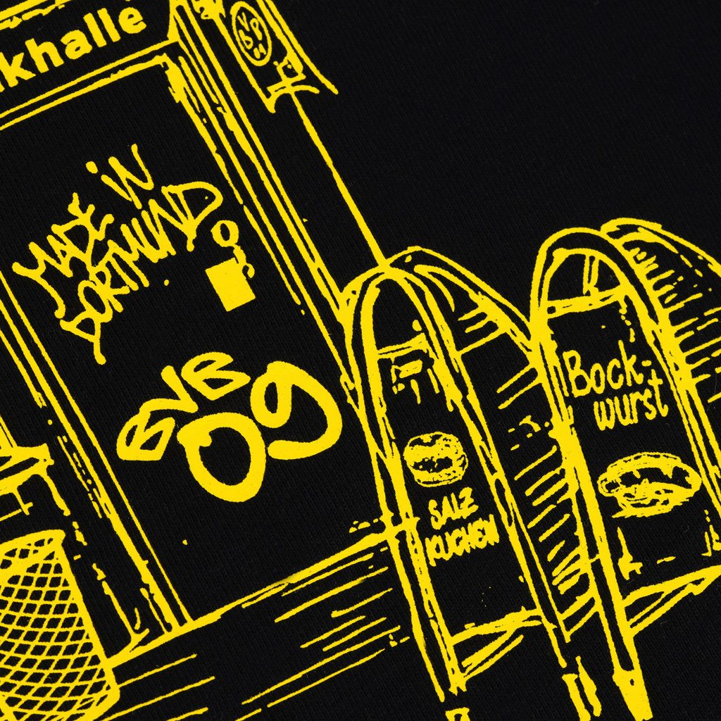 BVBの「Trinkhalle」と書かれた黒のTシャツで、黄色いプリントが施されています。プリントには、「Trinkhalle」のイラストに加え、BVB 09のロゴ、塩プレッツェルといったドルトムントならではの要素、そして「Made in Dortmund」の文字が描かれています。