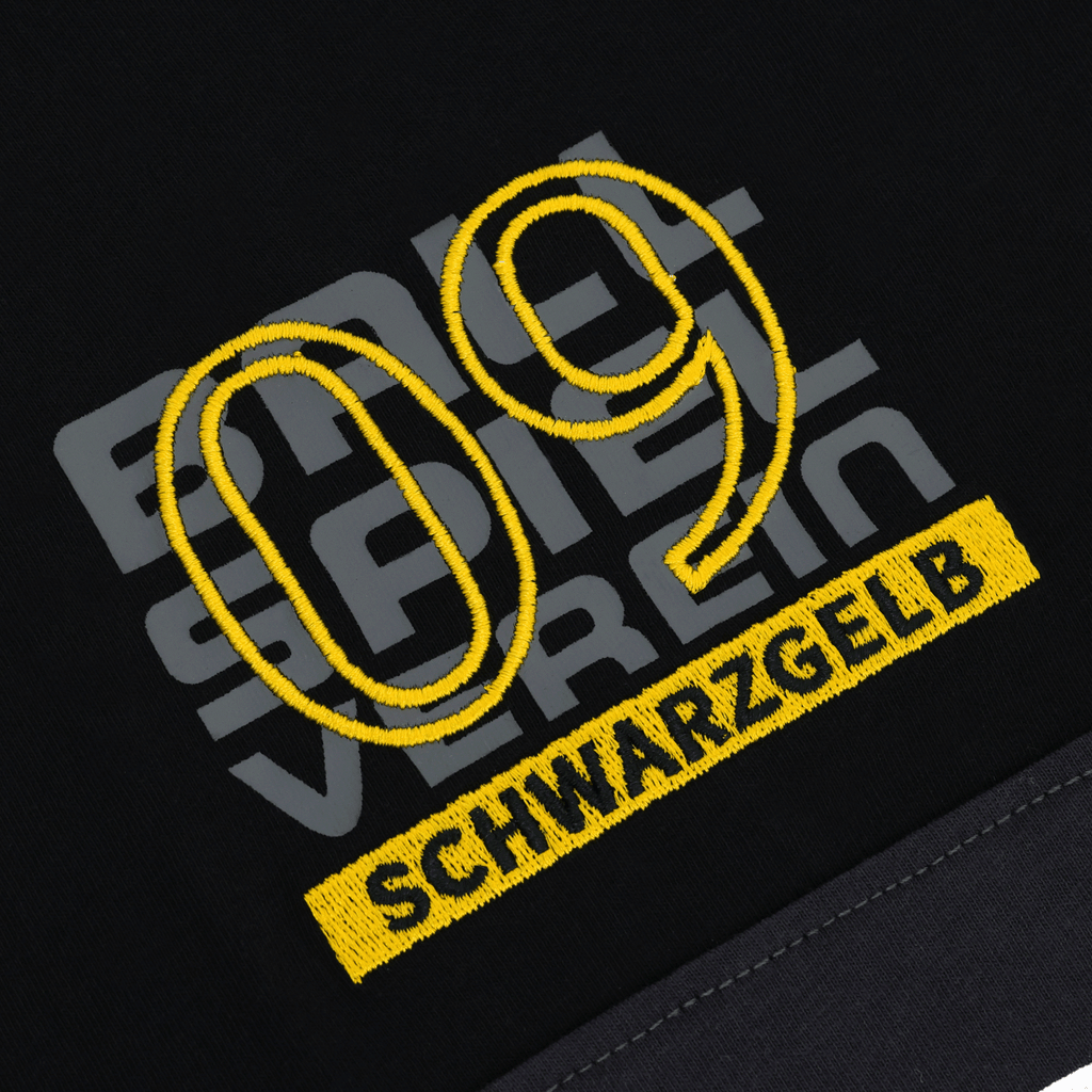 Nahaufnahme des BVB Elements II T-Shirts in Schwarz mit auffälliger gelber 09-Stickerei und 'schwarzgelb'-Schriftzug.