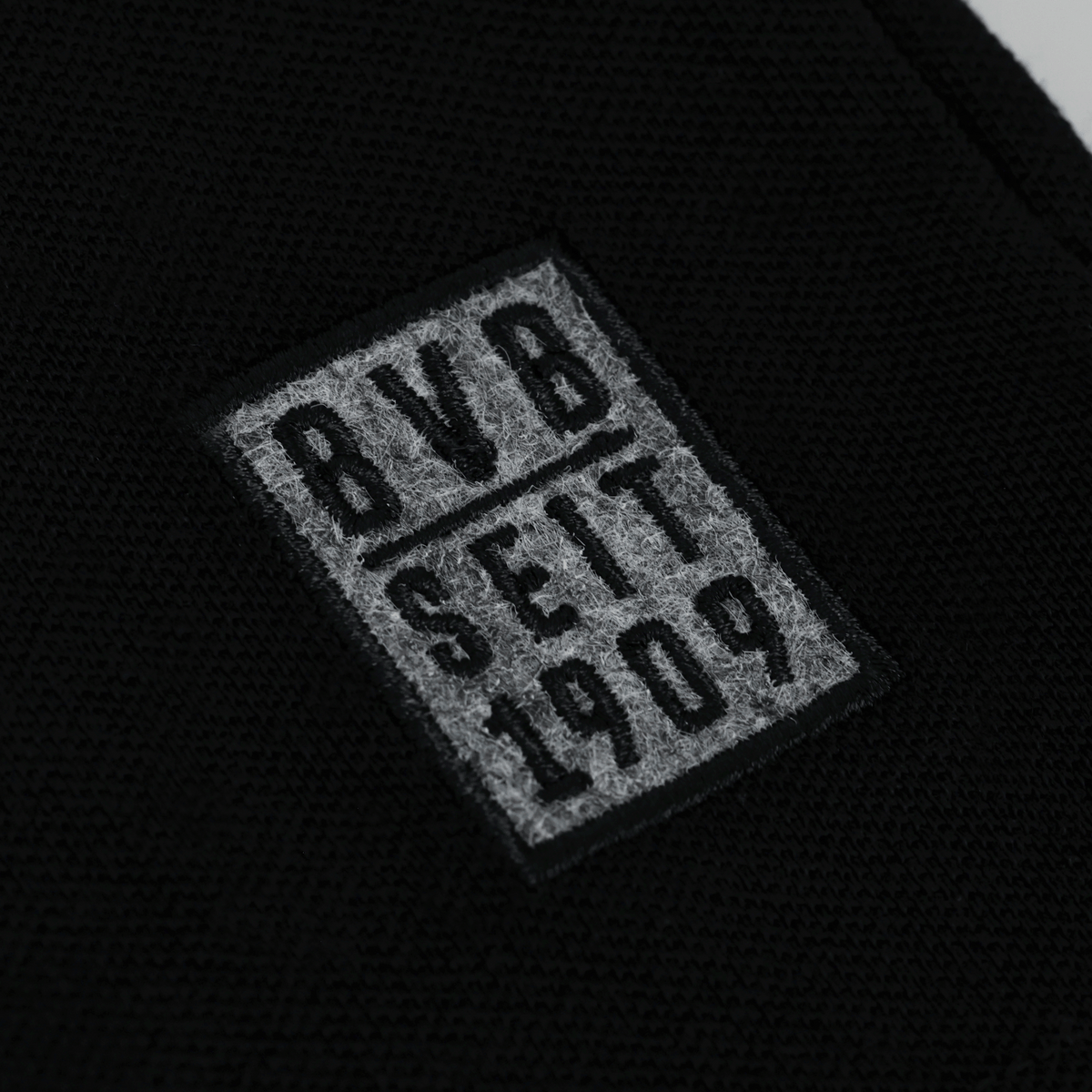 グレーのBVBロゴと「BVB seit 1909」の文字が入った、黒のBVBポロシャツの詳細画像。