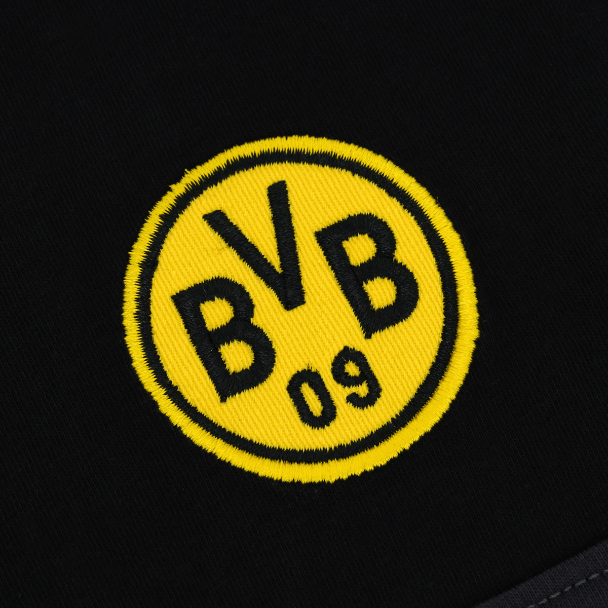 La photo montre un gros plan du logo jaune du BVB 09 sur un fond noir 