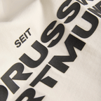ベージュ色のBVB Tシャツ「Essentials II」に、黒い文字で「Seit Borussia Dortmund」と書かれた部分をクローズアップした写真。ボルシア・ドルトムントのファンアイテム。