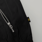 ジッパーが表に出ている、黒と黄色のBVBラベルが付いた「Essentials II」のBVBジャケットのクローズアップ。