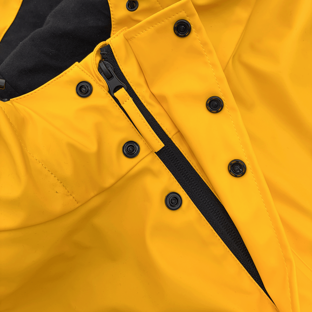 Impermeabile giallo del BVB modello Essentials II con bottoni neri e cerniera, ideale per le attività all'aperto e le giornate piovose.