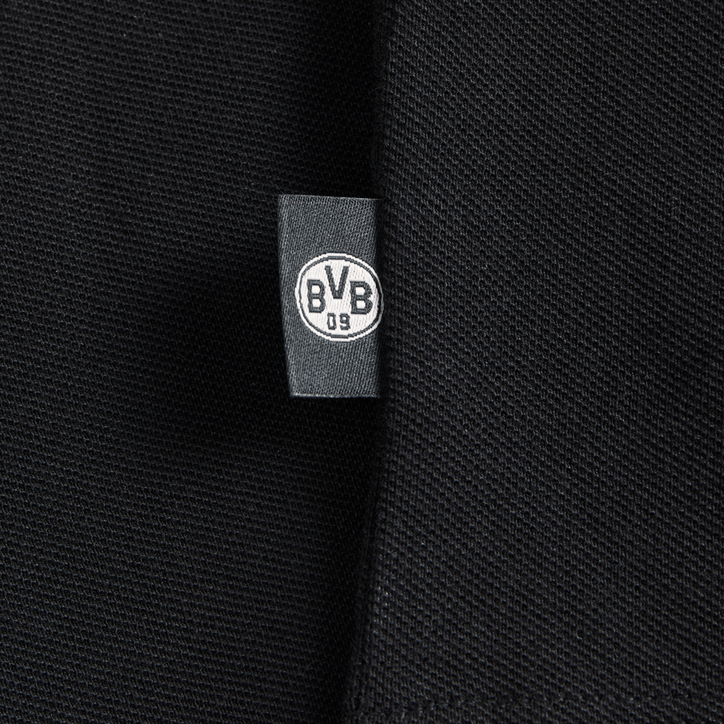 Primo piano di un tessuto nero con il logo del BVB su un'etichetta, ideale per i tifosi del Borussia Dortmund.