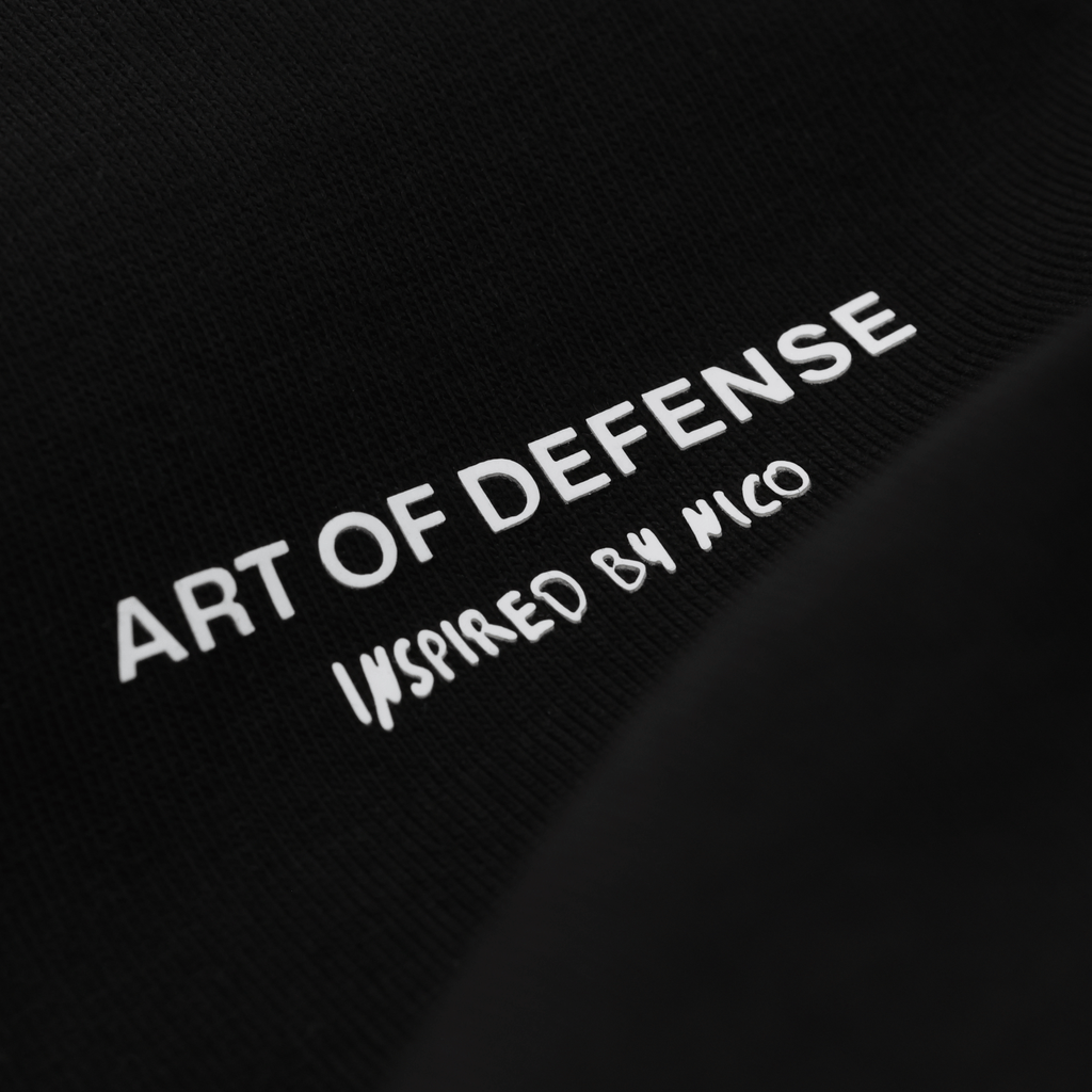 Camiseta negra del BVB con la inscripción en blanco «Art of Defense - Inspired by Nico», ideal para los aficionados del Borussia Dortmund.