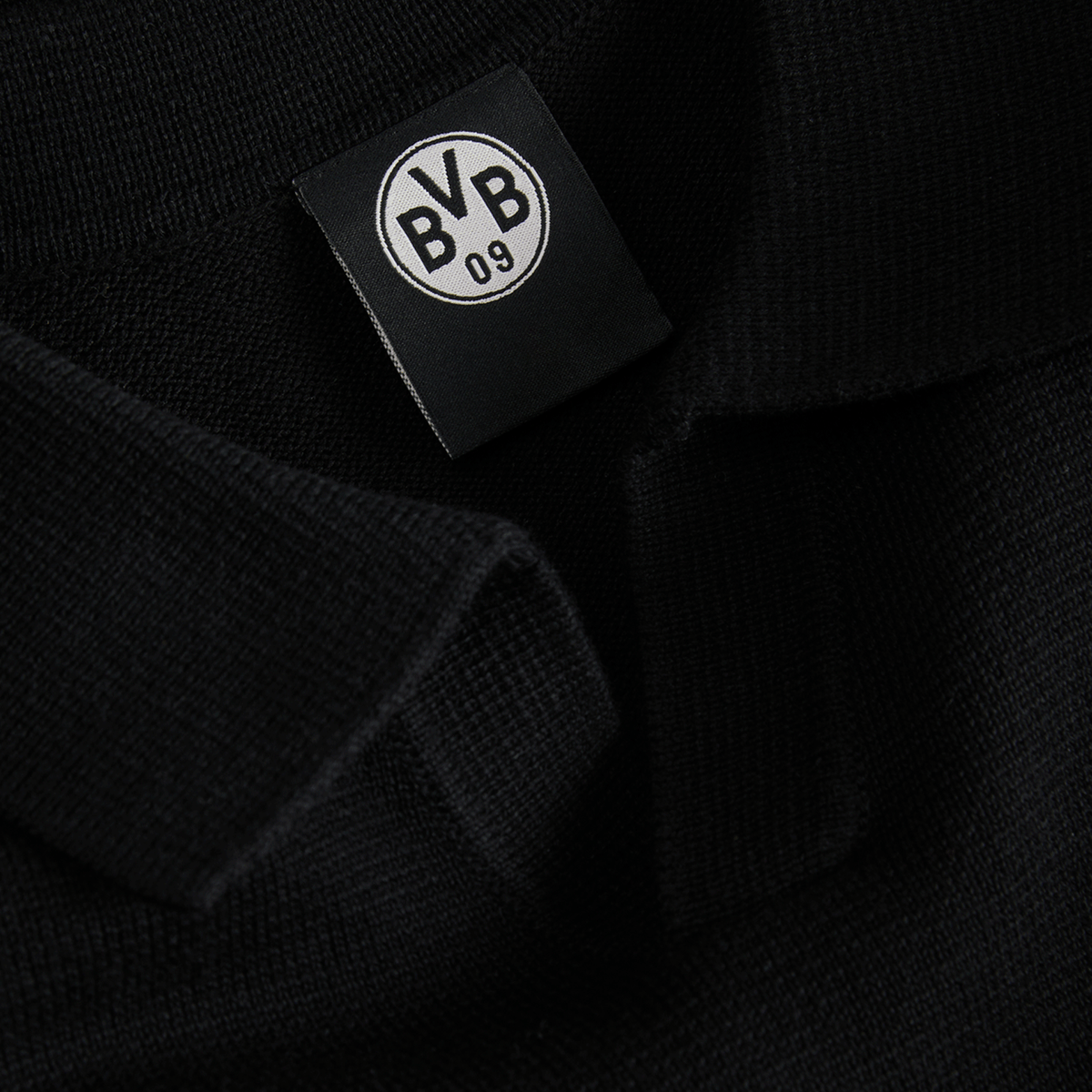 Primo piano di un capo di abbigliamento nero con il logo BVB 09 su un'etichetta.