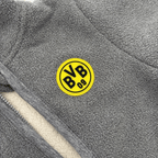 Mono gris del BVB de felpa de peluche para bebés con el logotipo amarillo del BVB 09; muestra un primer plano del suave tejido.