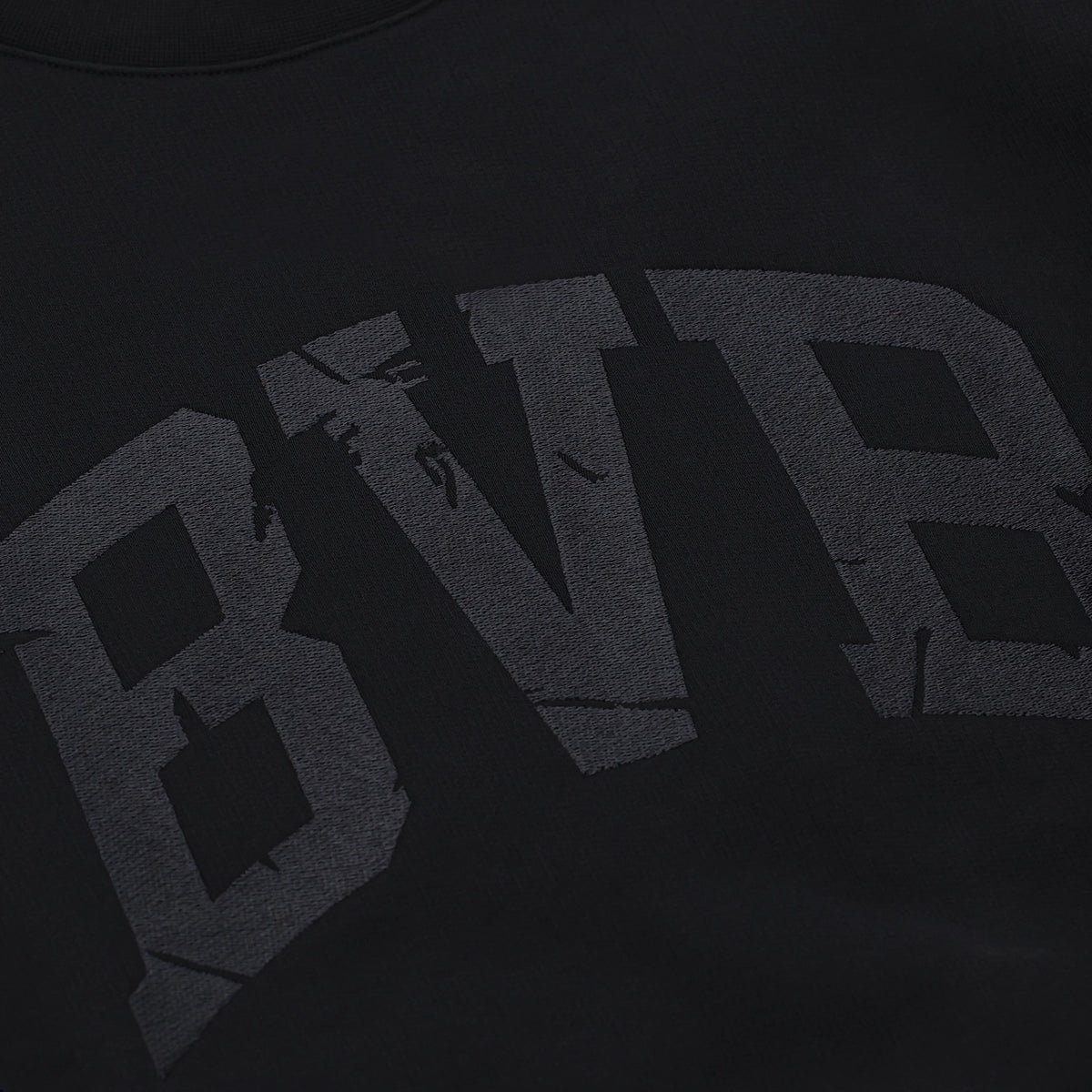 Vue détaillée d'un pull noir du BVB orné d'un grand logo BVB en relief, issu de la collection Heat II.