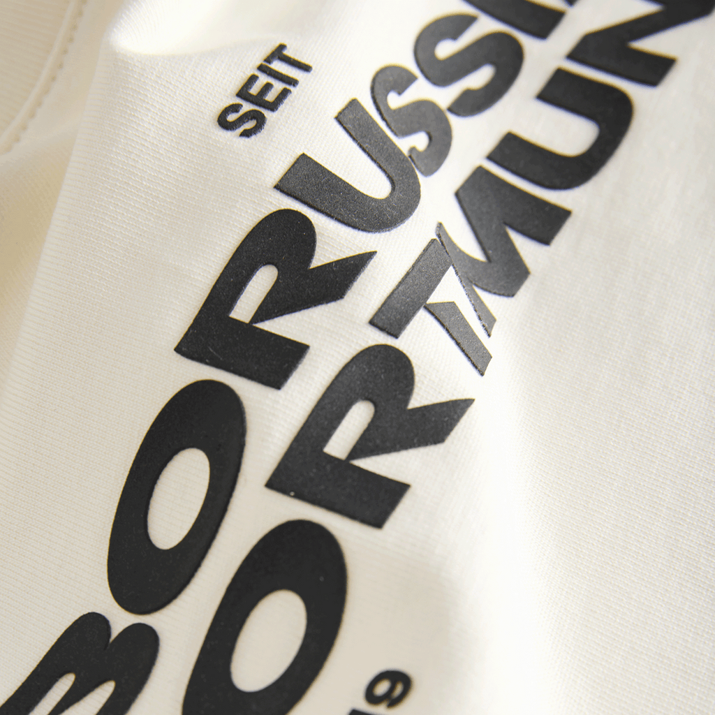 Beige BVB Essentials II T-shirt for kids with black "Borussia Dortmund" lettering and the year 1909; fan merchandise for soccer fans.