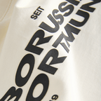 Beige BVB Essentials II T-shirt for kids with black "Borussia Dortmund" lettering and the year 1909; fan merchandise for soccer fans.